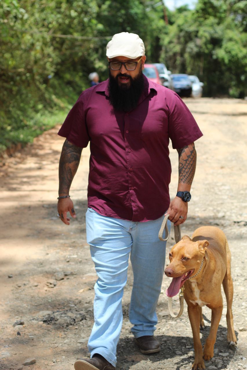 Cliente caminhando com cão reabilitado em estrada de terra